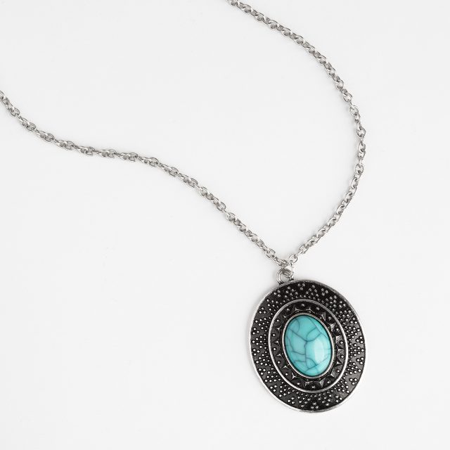 An eCommerce product shot showing a necklace laid out elegantly on a light grey background.